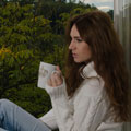 Simone sitzt auf der Fensterbank und trinkt Tee